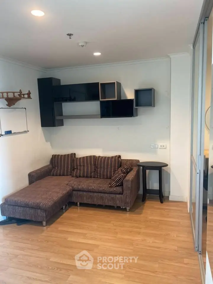 Cozy living room with modern sectional sofa and stylish wall shelves, perfect for relaxation and entertainment.