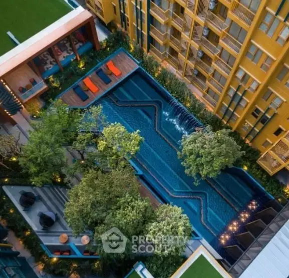 Luxurious aerial view of modern apartment complex with stunning pool and lush greenery.