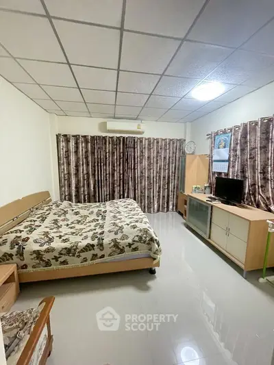 Spacious bedroom with modern furnishings and ample natural light.