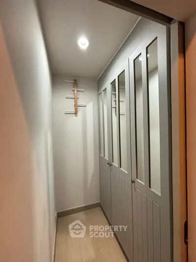 Spacious walk-in closet with mirrored doors and modern lighting