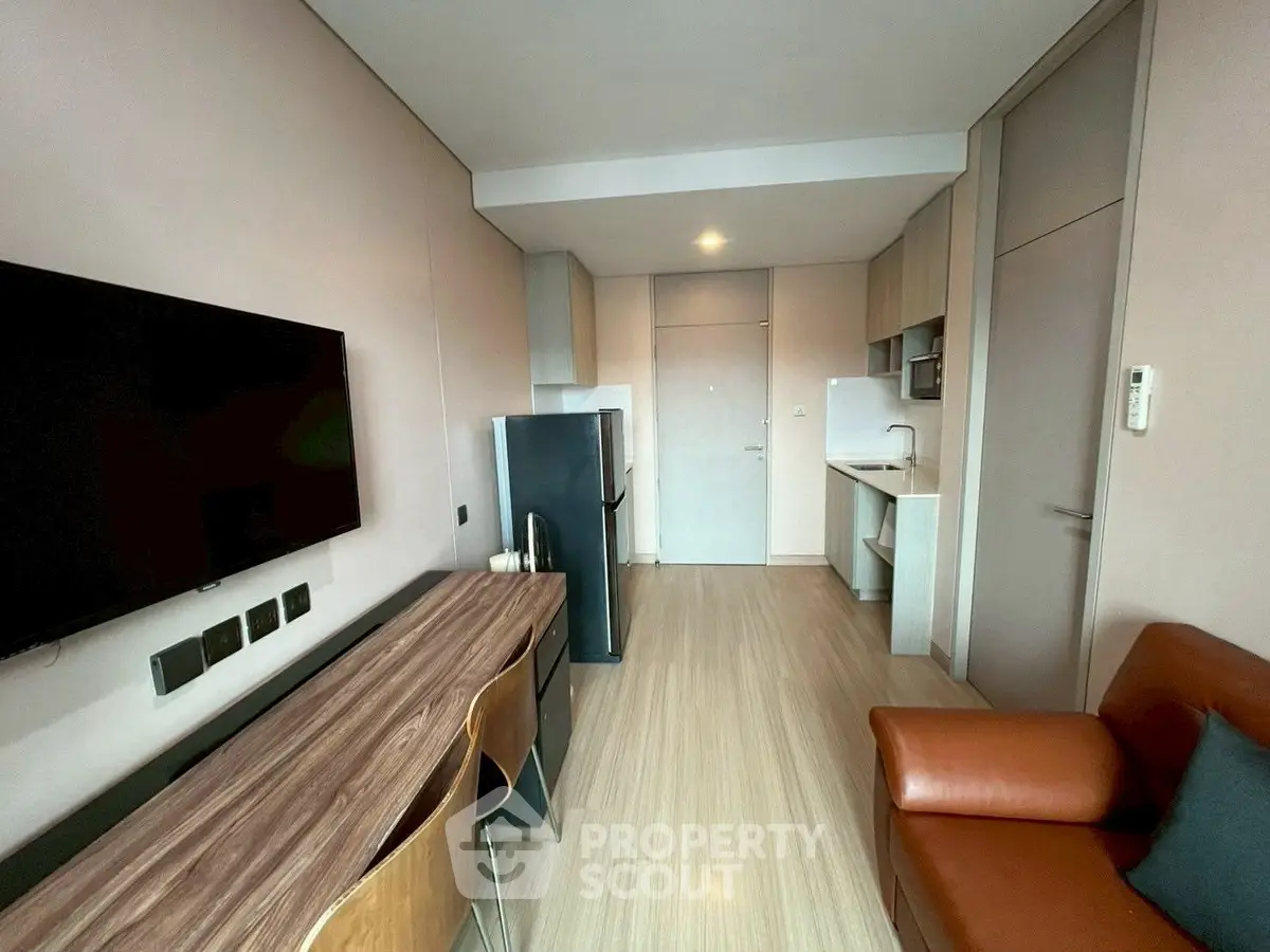 Modern compact living room with sleek furniture and integrated kitchen area