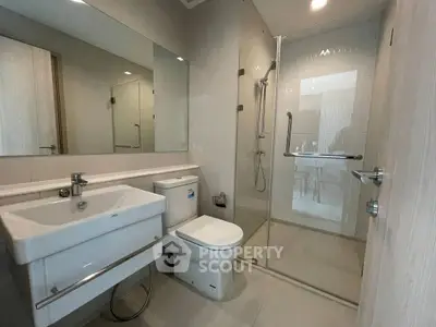 Modern bathroom with glass shower and sleek fixtures in a contemporary home.