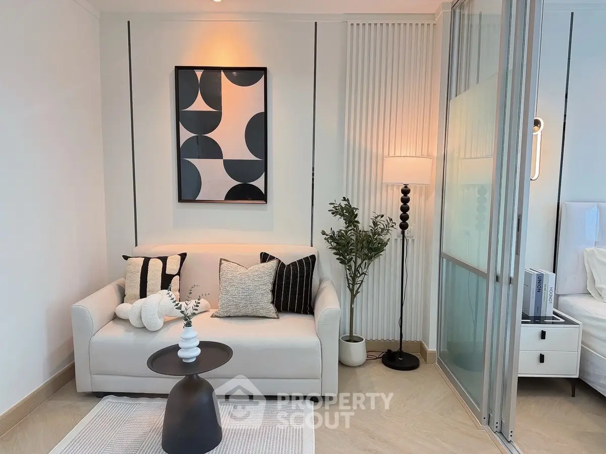 Modern living room with stylish decor and cozy seating area, featuring elegant lighting and contemporary artwork.