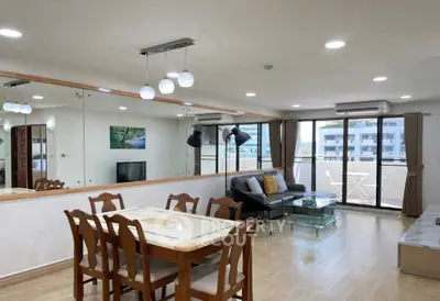 Spacious modern living room with dining area and large windows offering natural light and balcony access.