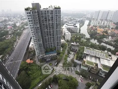 Stunning aerial view of modern high-rise building with lush greenery and cityscape, perfect for urban living.
