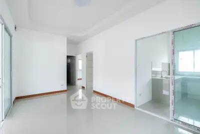 Spacious and bright empty room with sliding glass doors and tiled floor