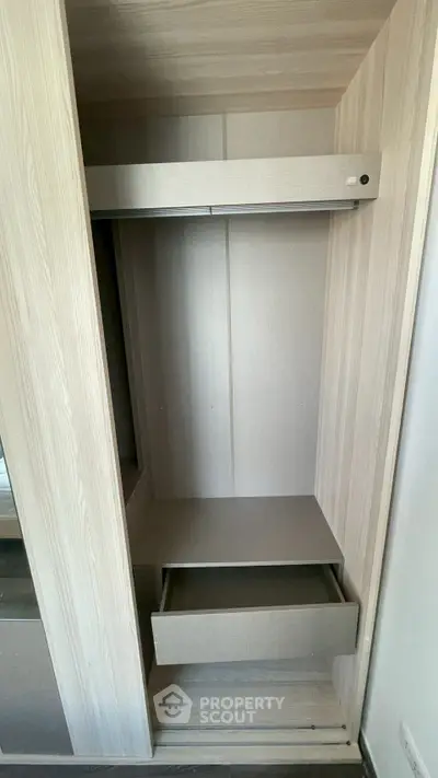 Spacious built-in wardrobe with open drawer in modern apartment