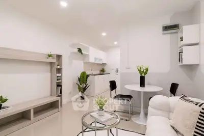 Modern minimalist living room with open kitchen, white furniture, and elegant decor.