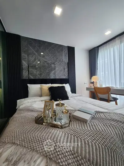Luxurious bedroom with elegant decor and natural light, featuring a cozy bed and stylish furnishings.