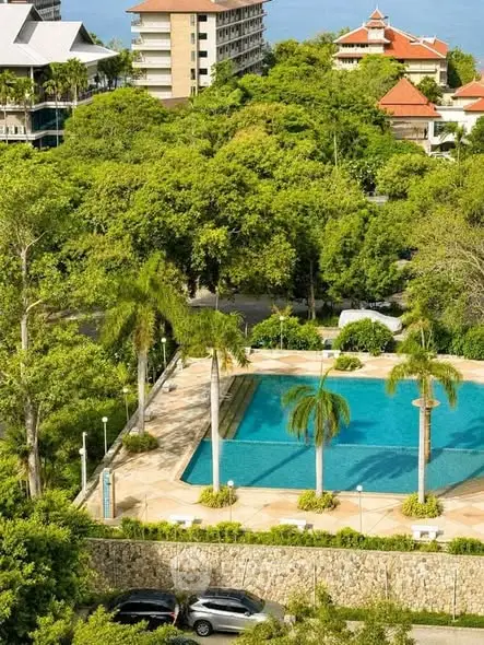 Luxurious residential complex with lush greenery and inviting swimming pool.
