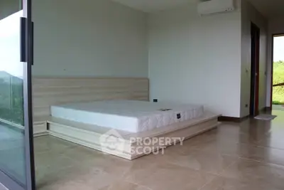 Spacious bedroom with modern design and large sliding glass doors opening to a scenic view.