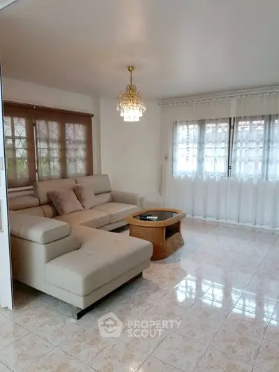 Spacious living room with elegant chandelier and cozy sectional sofa
