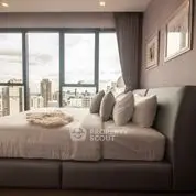 Luxurious bedroom with stunning city view and elegant decor in high-rise apartment.