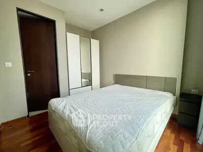 Modern bedroom with sleek design and wooden flooring, featuring a minimalist aesthetic.