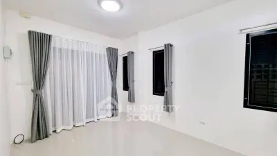 Spacious unfurnished room with large windows and modern curtains