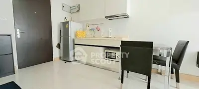 Modern compact kitchen with sleek cabinets and dining area in cozy apartment.