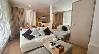 Modern living room with cozy seating and stylish decor in open layout apartment.