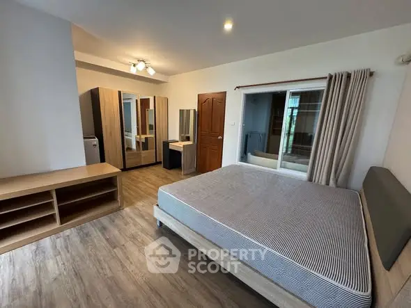 Spacious bedroom with modern furnishings and ample natural light, perfect for comfortable living.