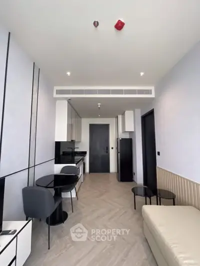 Modern open-plan living room with sleek kitchen and stylish furniture in a contemporary apartment.