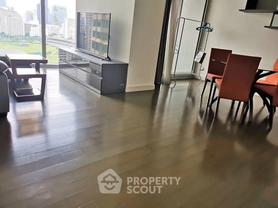 Spacious modern living room with city view, sleek wooden flooring, and stylish furniture.