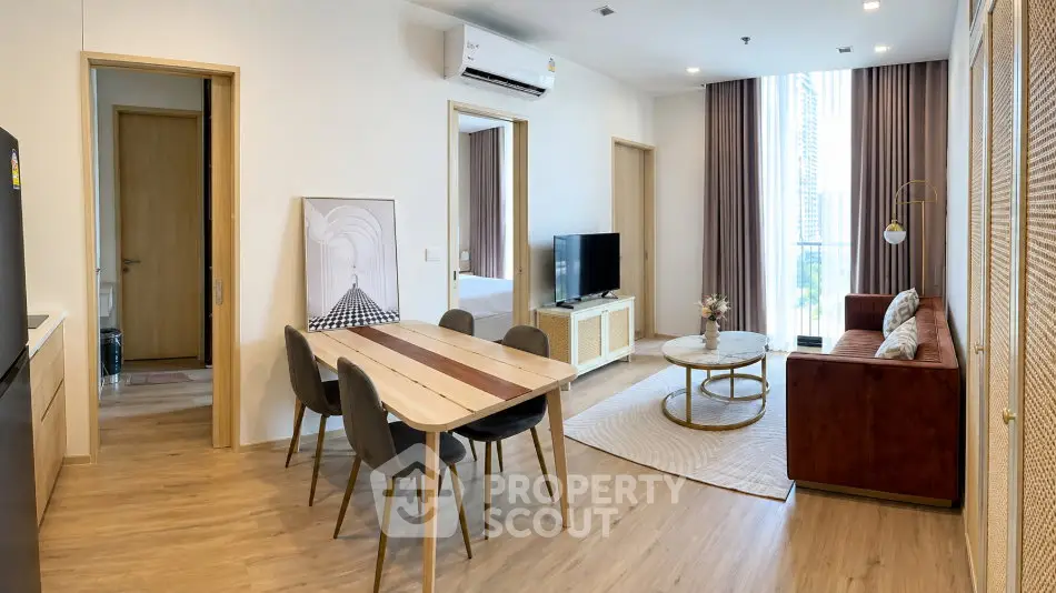 Modern living room with dining area, stylish furniture, and large windows in a contemporary apartment.