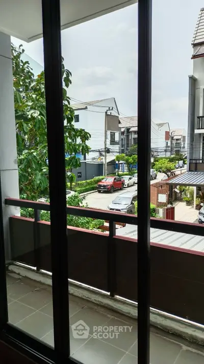 Charming balcony view overlooking a suburban neighborhood with lush greenery and modern houses.