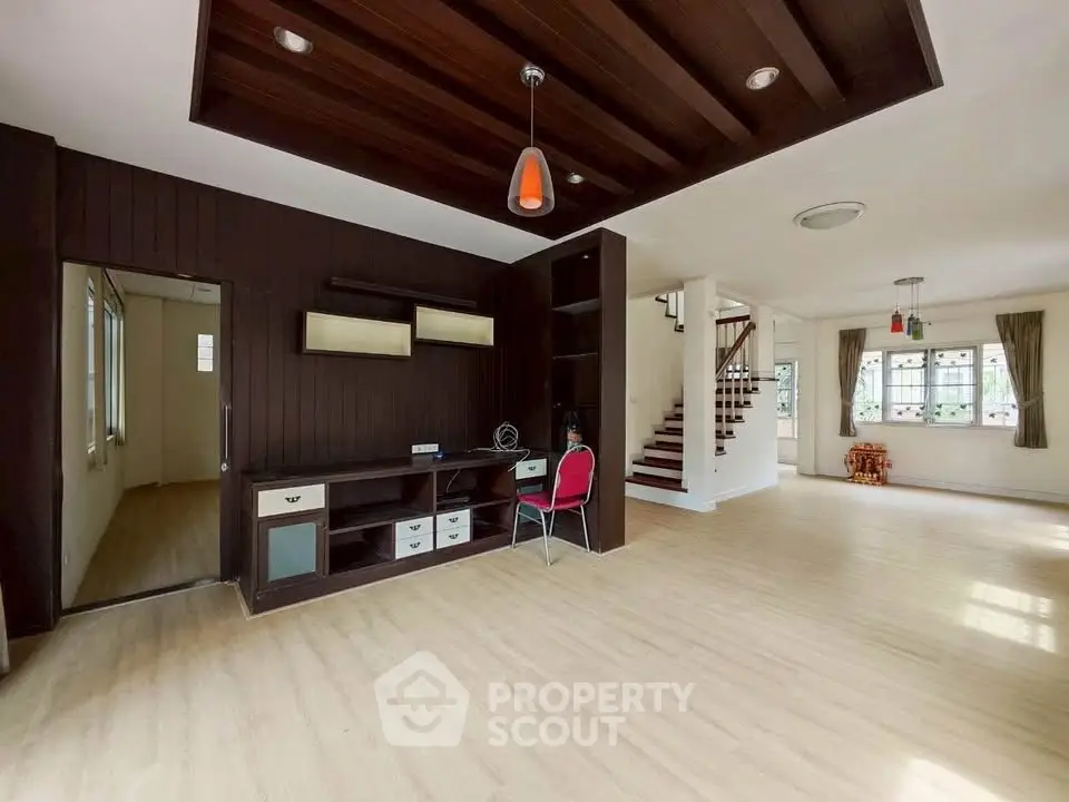 Spacious open-plan living room with modern wooden accents and natural light.