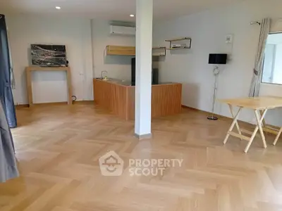 Spacious open-plan living area with modern kitchen and stylish wooden flooring.