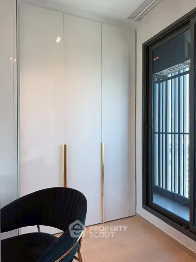 Modern interior with sleek closet and elegant chair by large window.