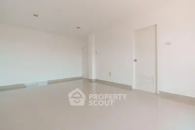 Spacious empty room with glossy tiled floor and white walls, ideal for customization.