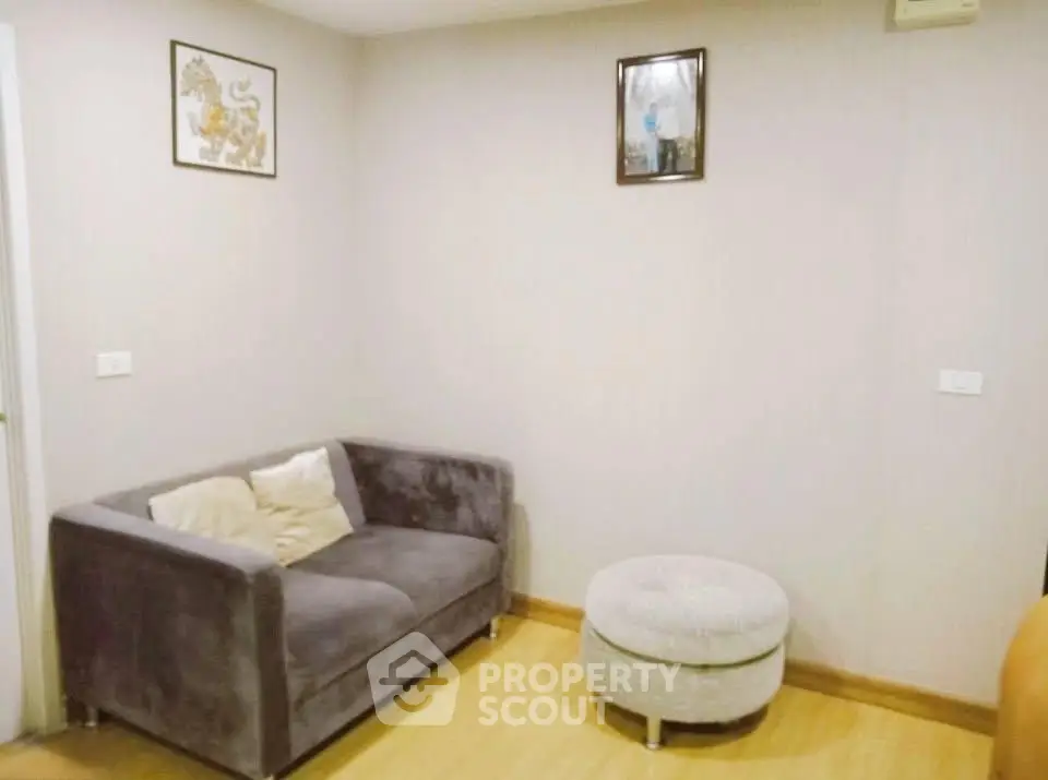 Cozy living room with plush gray sofa and matching ottoman, perfect for relaxation.