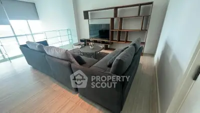 Spacious living room with modern sectional sofa and stylish shelving unit.