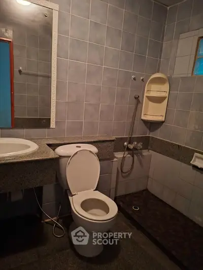 Spacious bathroom with modern fixtures and tiled walls in a real estate property.