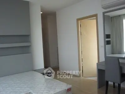 Modern bedroom with minimalist design and ample natural light, featuring a sleek vanity and built-in shelving.
