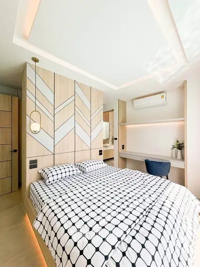 Modern bedroom with stylish decor and built-in storage, featuring a cozy bed and ambient lighting.