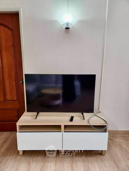 Modern living room with sleek TV stand and flat-screen TV, perfect for entertainment.