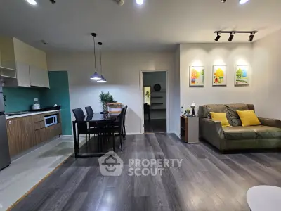 Modern open-plan living room with stylish kitchen and dining area, featuring sleek flooring and contemporary decor.