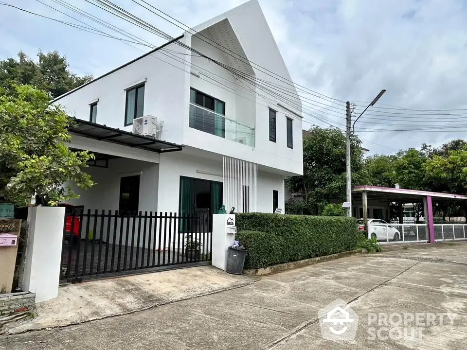 Modern two-story house with sleek design and lush greenery in a serene neighborhood.