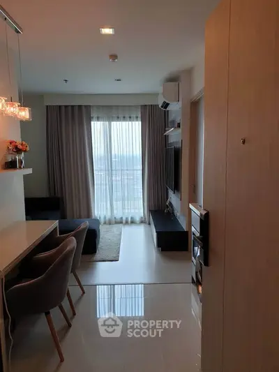 Modern living room with elegant decor and large window offering natural light.