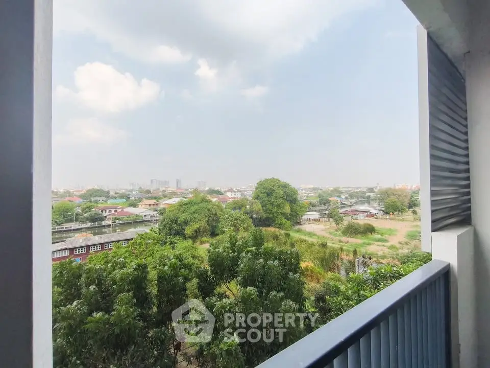Stunning balcony view overlooking lush greenery and cityscape, perfect for relaxation and enjoying nature.