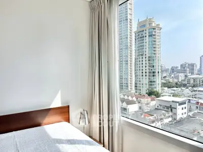 Bright bedroom with city view from large window in modern apartment