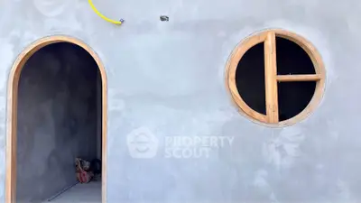 Unique architectural design with circular window and arched doorway in modern construction.