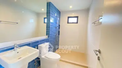 Modern bathroom with blue accent tiles and sleek fixtures