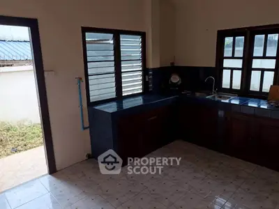 Spacious kitchen with tiled floor and ample natural light