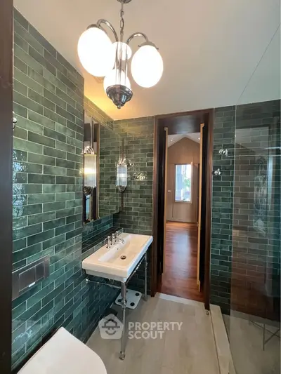 Luxurious bathroom with green tile walls and elegant lighting fixtures