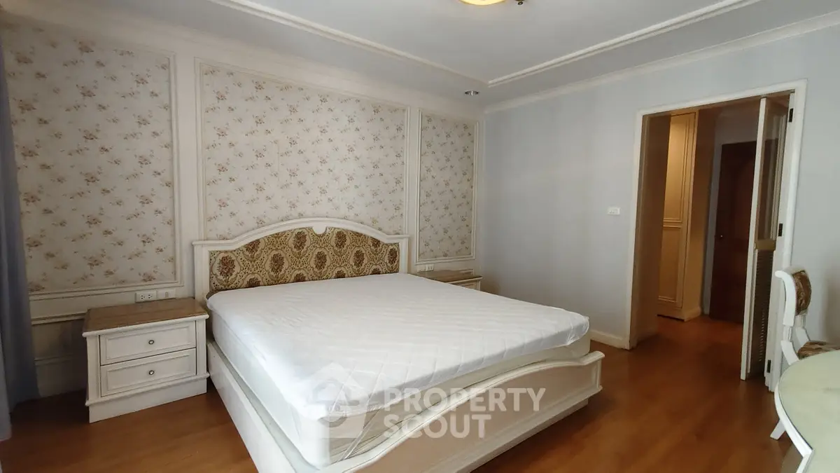 Elegant bedroom with classic decor and wooden flooring in a cozy apartment.