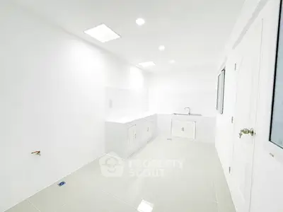 Spacious white kitchen with modern fixtures and ample natural light