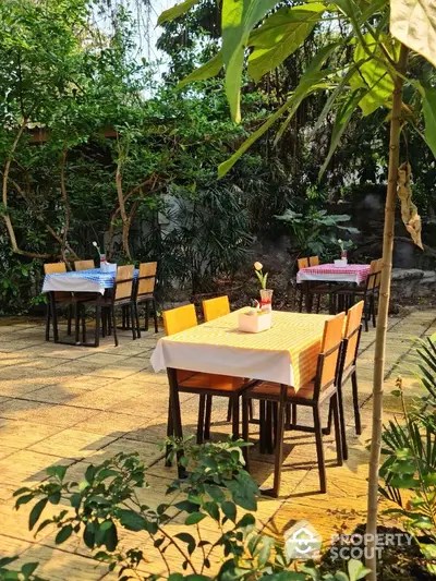 Charming outdoor garden dining area with colorful tablecloths and lush greenery