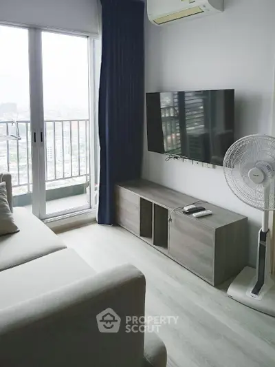 Modern living room with balcony view, featuring sleek furniture and natural light.