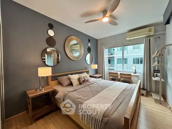 Modern bedroom with stylish decor, large window, and cozy ambiance in a contemporary apartment.
